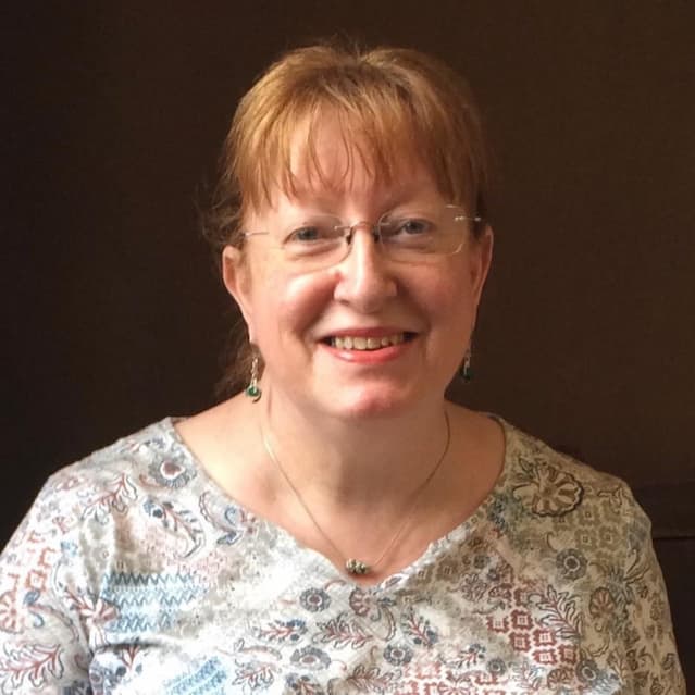 A photograph of Jackie Burns, a white woman with light hair, looking at the camera and smiling.