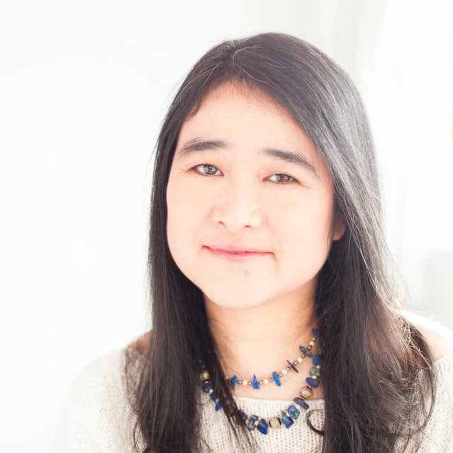 An photograph of Michelle Sagara, an Asian woman with dark hair, looking into the camera.